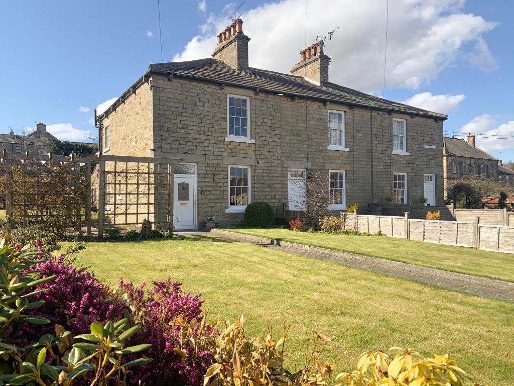 a large brick house with a yard in front of it at Miners Cottage in Middleton in Teesdale