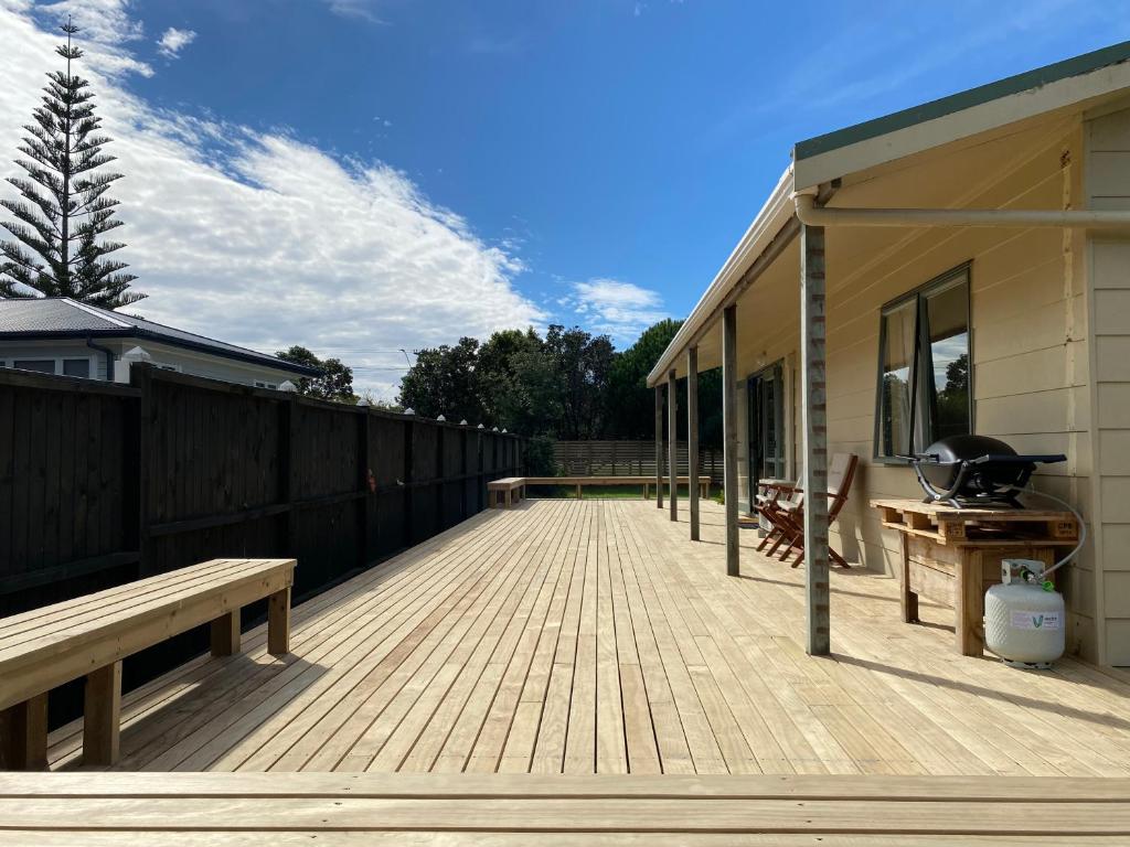 a large wooden deck with a grill on a house at Hibiscus House - Mangawhai Heads Holiday Home in Mangawhai