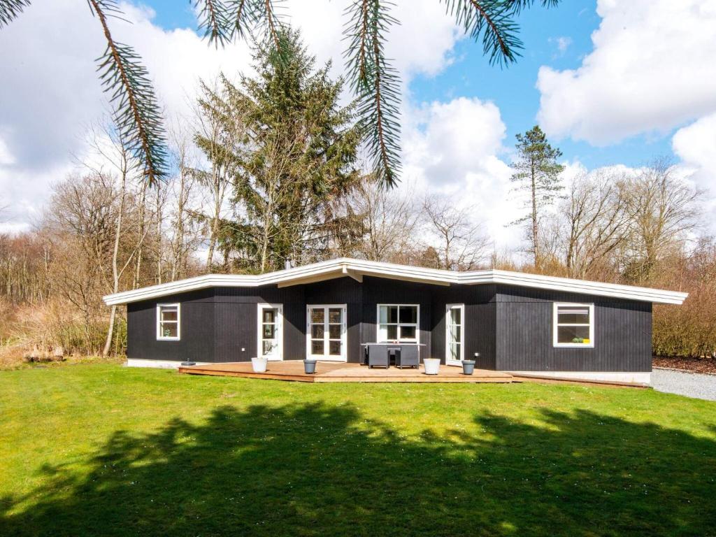 ArrildにあるFour-Bedroom Holiday home in Toftlund 6の緑の芝生の小さな黒い家