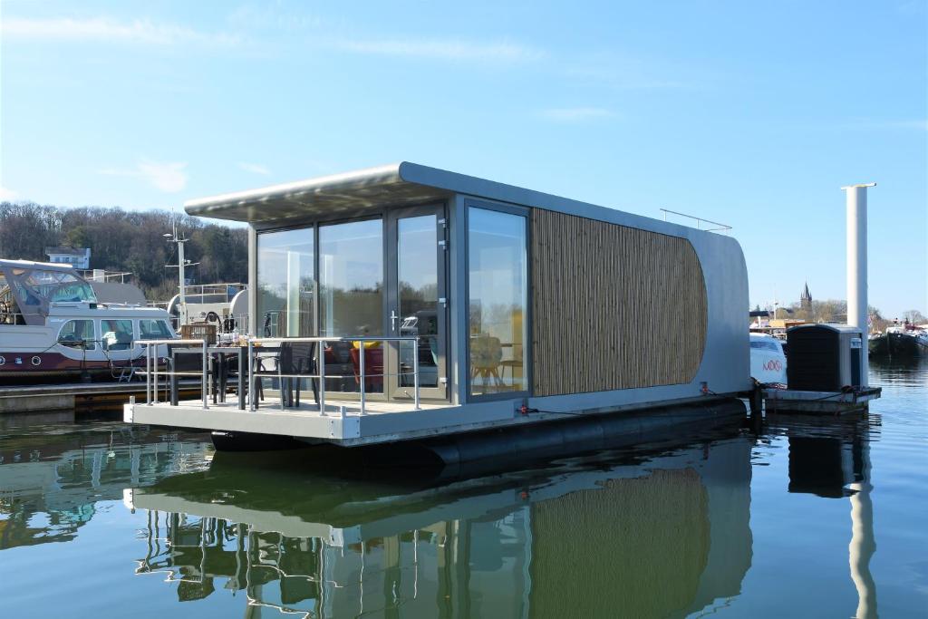 een klein huisje op een dok op een waterlichaam bij Floating vacationhome Sylt in Maastricht