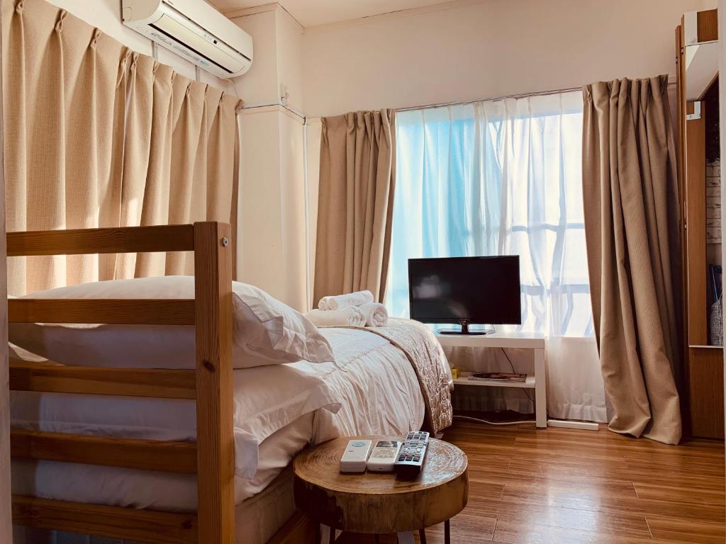 - une chambre avec des lits superposés et une télévision dans l'établissement COCO Nakameguro301, à Tokyo