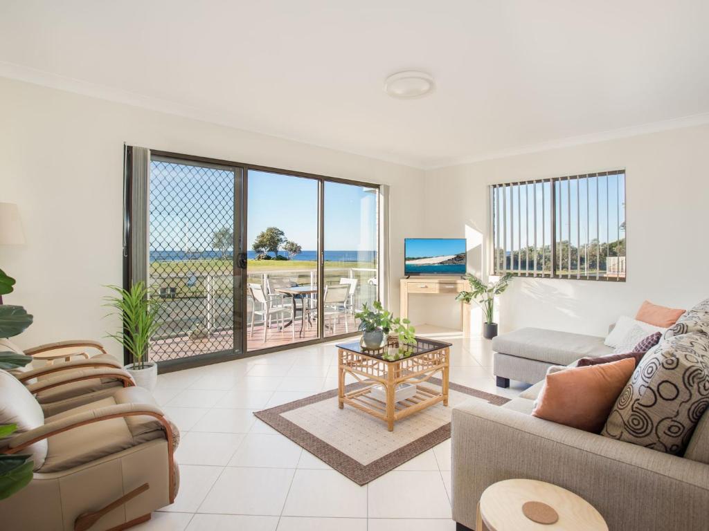 a living room with a view of the ocean at Villa Bianca 10 opposite the Tanks in Forster