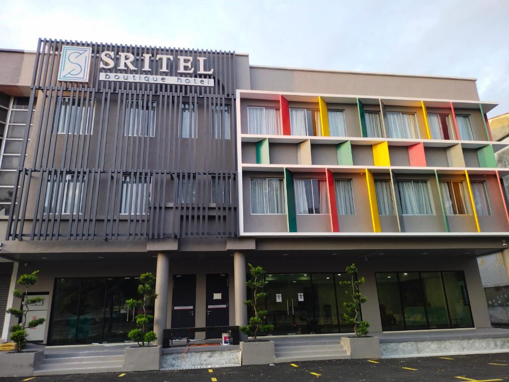 un edificio con ventanas coloridas y una señal en él en SRITEL BOUTIQUE HOTEL en Shah Alam