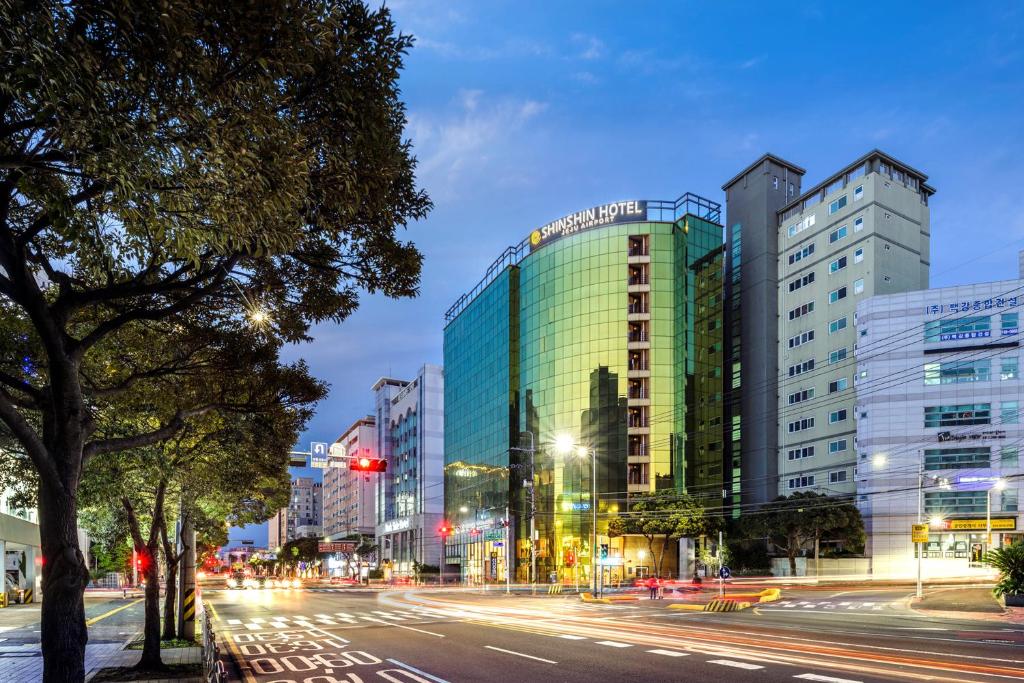 a city street at night with a building at Shin Shin Hotel Jeju Airport in Jeju