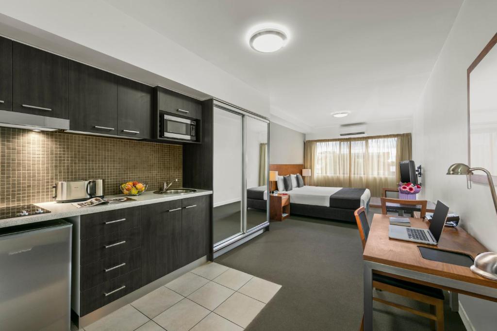 a kitchen and a living room with a couch at Quest Dubbo in Dubbo