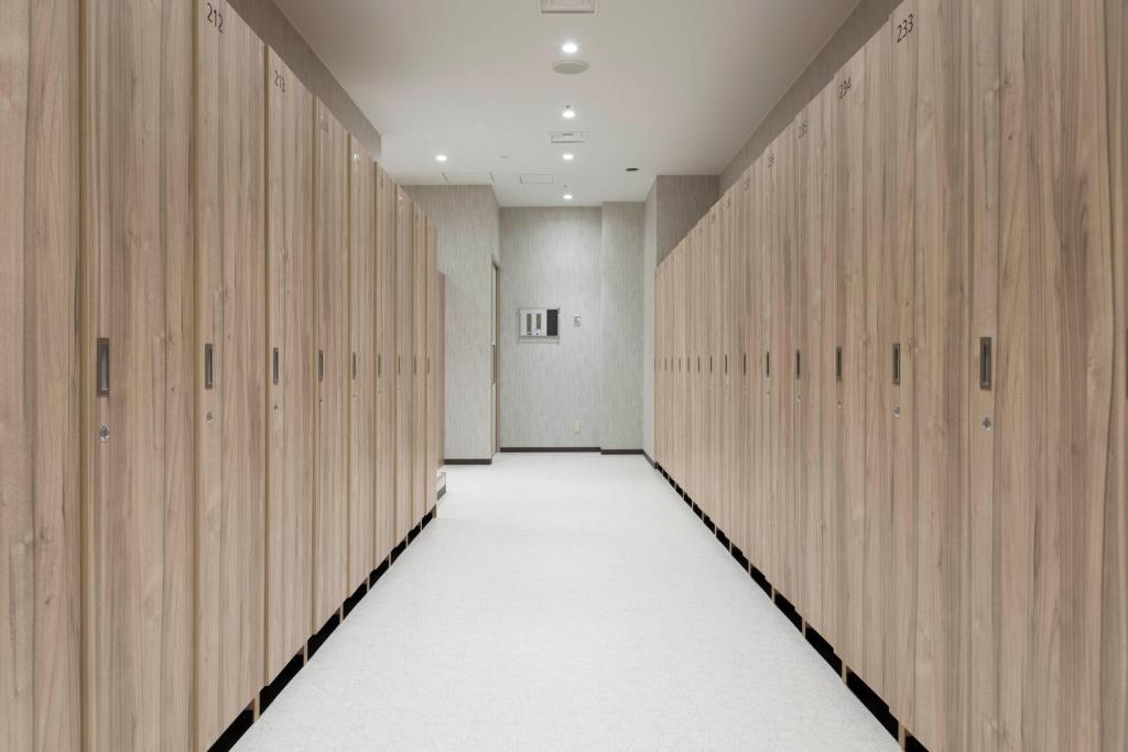 a hallway with wooden lockers in a gym at TUBE Sq in Tokoname