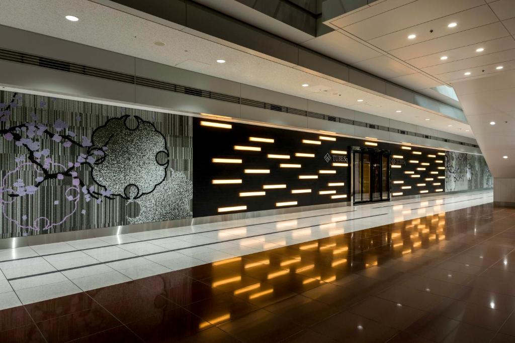 a hallway in a building with lights on the wall at TUBE Sq in Tokoname