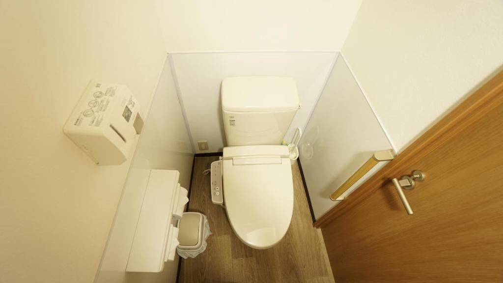 a white toilet sitting next to a white sink at House Ikebukuro in Tokyo