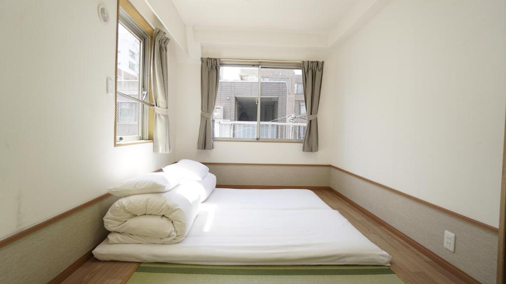 東京的住宿－池袋賓館，窗户客房内的小床