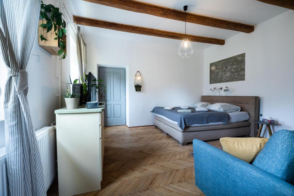 una camera con letto e sedia blu di Miliő Apartman Badacsony a Badacsonytördemic