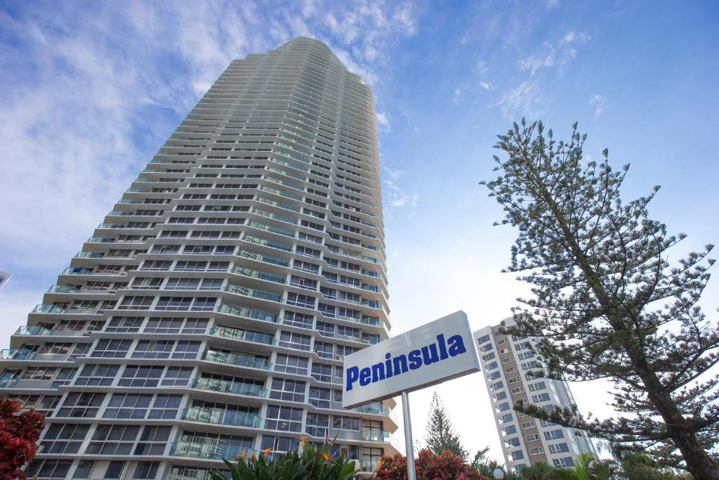 a tall building with a sign in front of it at BreakFree Peninsula in Gold Coast