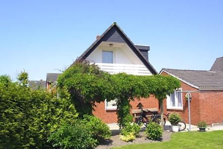 a house with a bench in front of it at Ferienwohnungen im Haus Nordseebrise in Neuharlingersiel