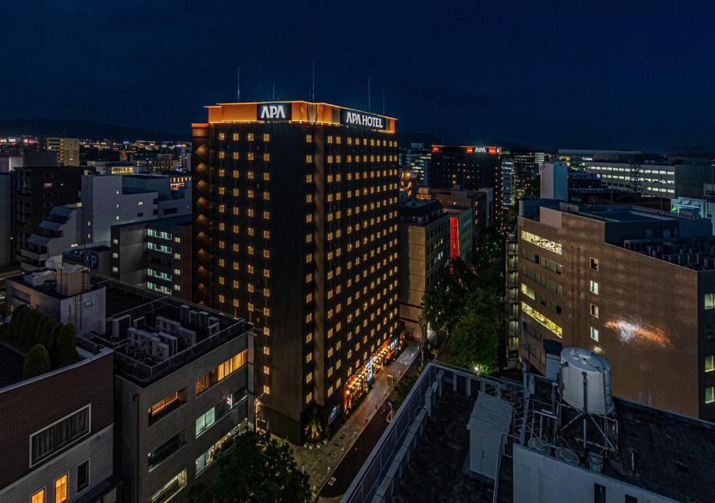 福岡的住宿－APA Hotel Hakata Eki Chikushiguchi，一座高大的建筑,上面有夜间标志