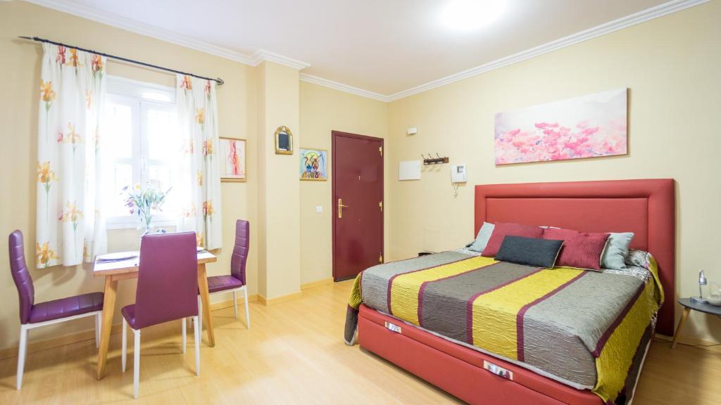 - une chambre avec un lit, une table et des chaises dans l'établissement Palacio de las Dueñas, à Séville