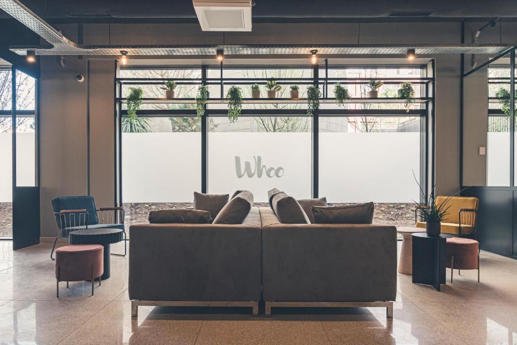 a living room with a couch in front of a window at Whoo Bordeaux Bacalan - Hostel in Bordeaux