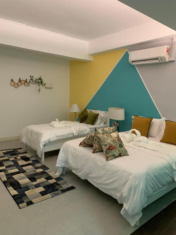 a bedroom with two beds and a blue wall at MyBed Homestay in Padang Besar