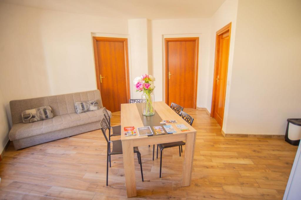- un salon avec une table et un canapé dans l'établissement Valery Apartments Alghero, à Alghero