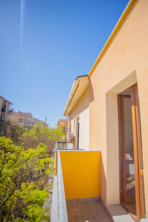 a house with a yellow door on the side of it at Valery Apartments Alghero in Alghero