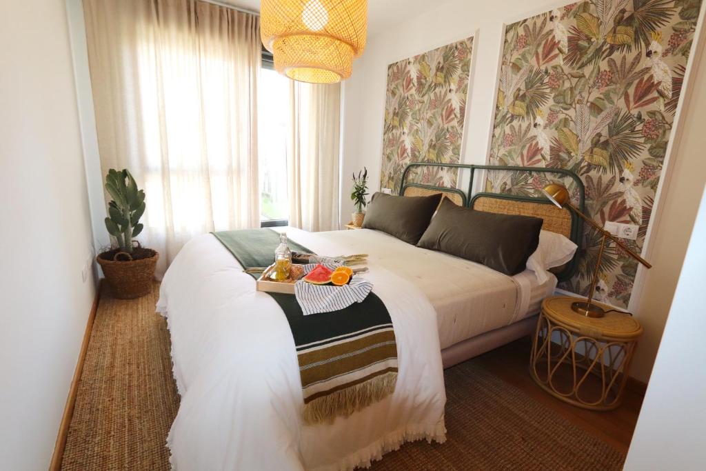 - une chambre avec un lit et un plateau de fruits dans l'établissement O Pisiño de Palmeira by Serendipia Turismo, à San Pedro