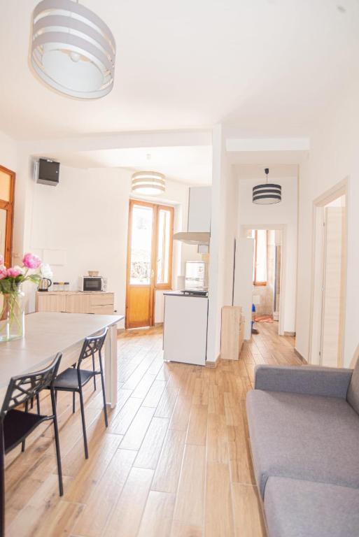 a kitchen and living room with a table and chairs at Valery Apartments Alghero in Alghero