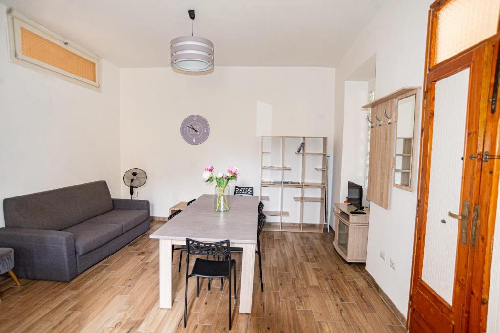 a living room with a table and a couch at Valery Apartments Alghero in Alghero