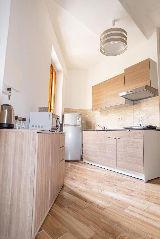 a kitchen with wooden cabinets and a refrigerator at Valery Apartments Alghero in Alghero