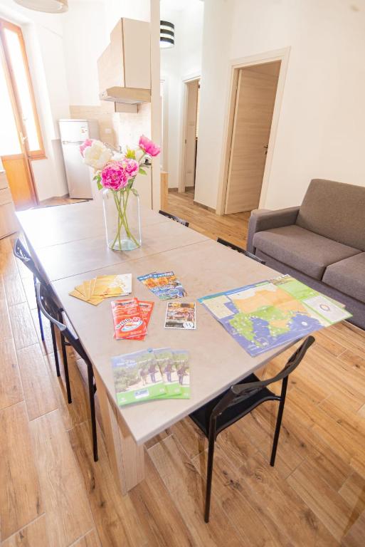 a table with flowers on it in a living room at Valery Apartments Alghero in Alghero