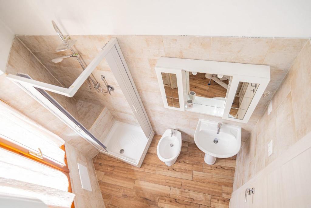 a bathroom with a sink and a toilet and a mirror at Valery Apartments Alghero in Alghero