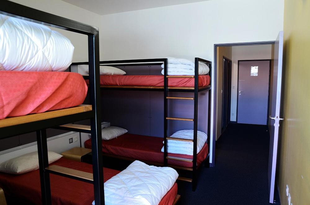 a room with four bunk beds and a hallway at Auberge de Jeunesse de Morlaix in Morlaix