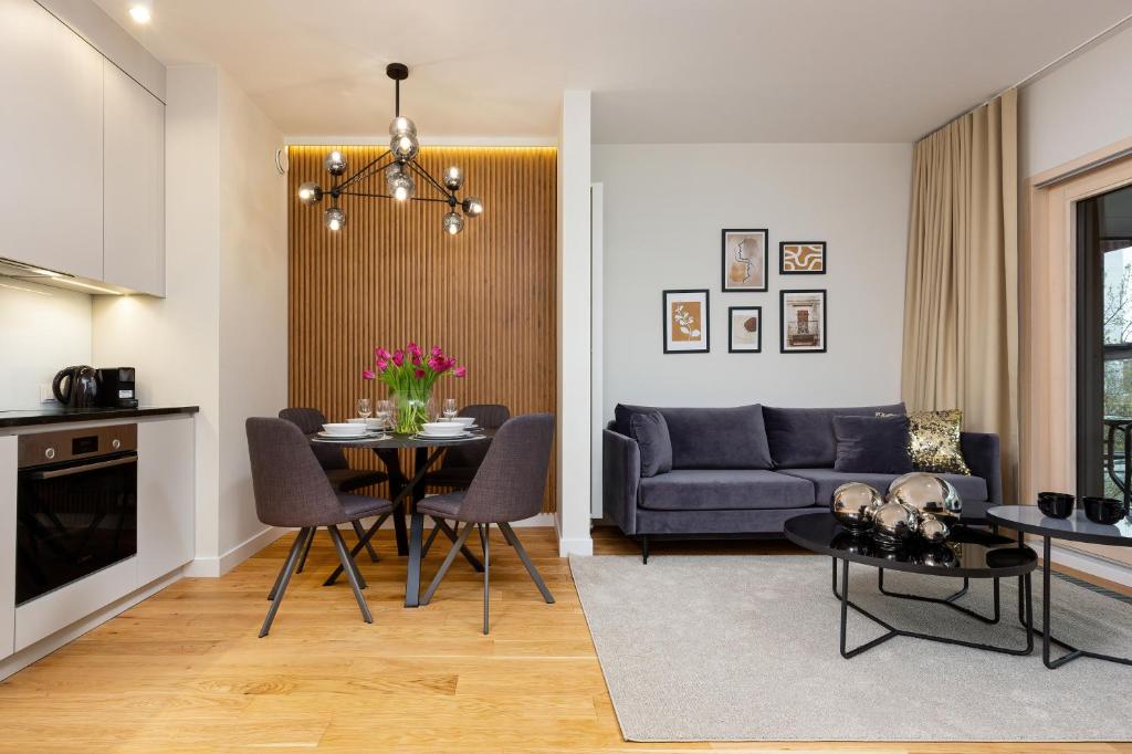 a living room with a blue couch and a table at Mennica Residence - City Center by Renters Prestige in Warsaw
