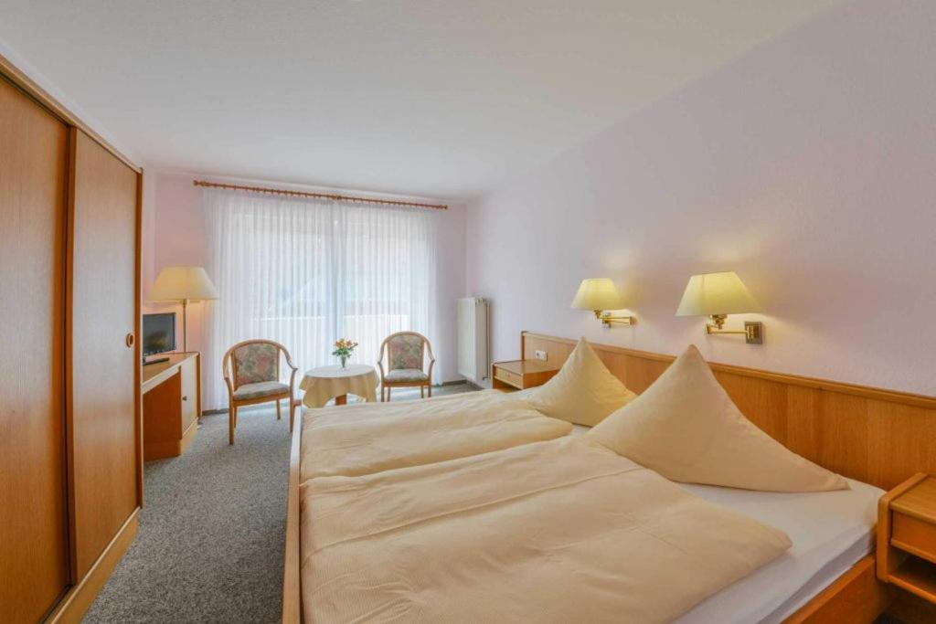 クックスハーフェンにあるLandhaus Brabandの大きなベッドとデスクが備わるホテルルームです。