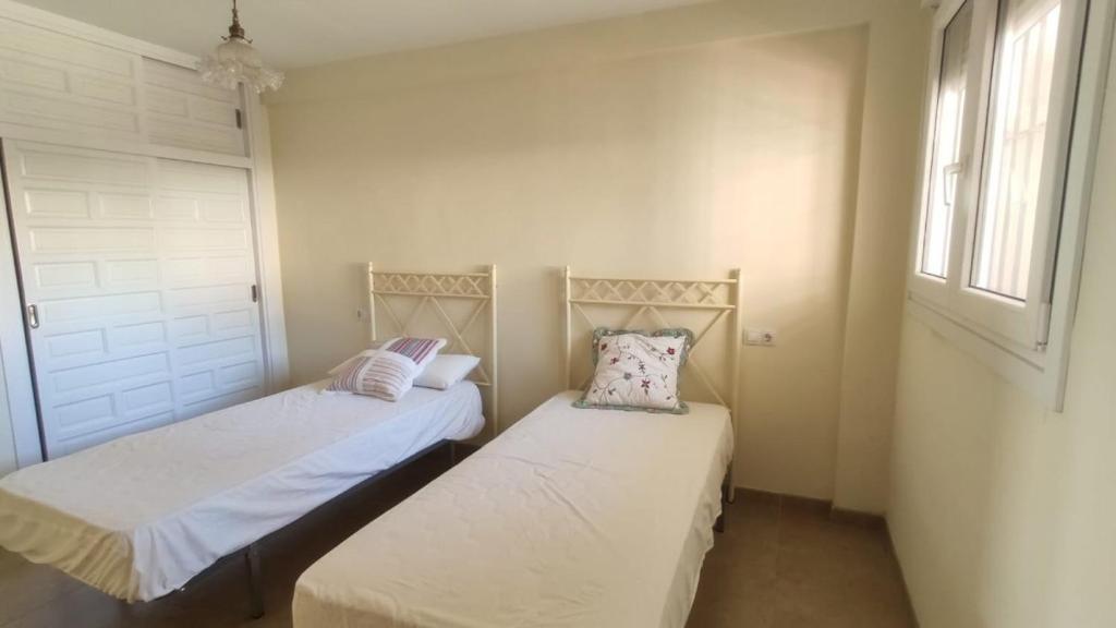 dwa łóżka pojedyncze w pokoju z oknem w obiekcie Expoholidays - Apartamentos en primera linea w mieście Aguadulce