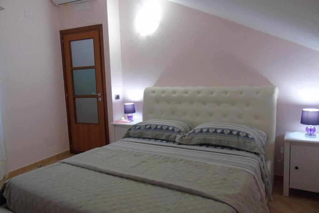a bedroom with a large bed with two night stands at Stella Maris Holidays in Maiori
