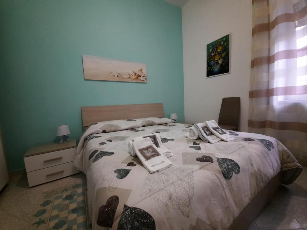 a bedroom with a bed with a comforter on it at Rose Apartment in Gaeta