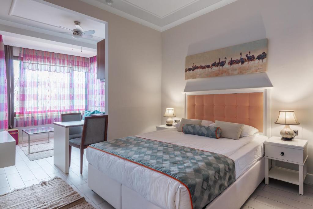 een slaapkamer met een groot bed en een bureau met een bureau bij Delight Deluxe Aparts in Antalya