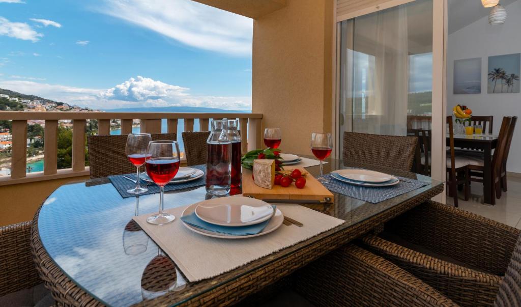 balcón con mesa de comedor y copas de vino en Apartment Angela, en Trogir