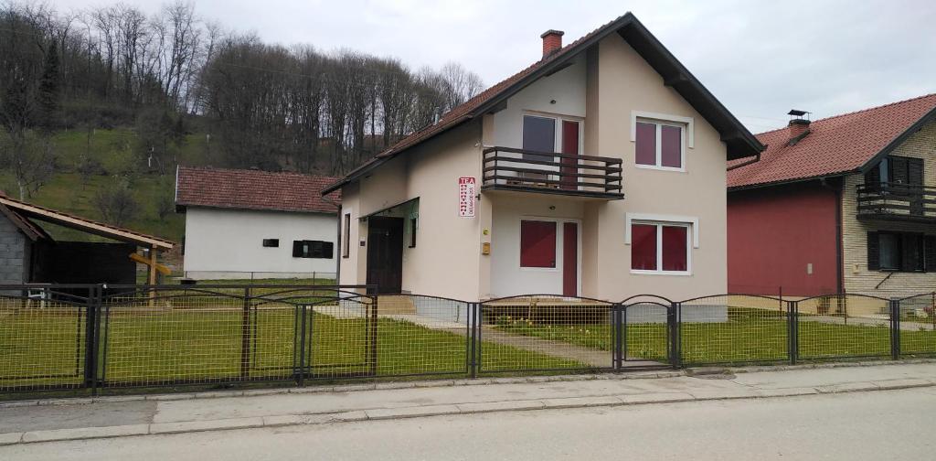 a white house with a fence in front of it at TEA Apartmani in Bajina Bašta