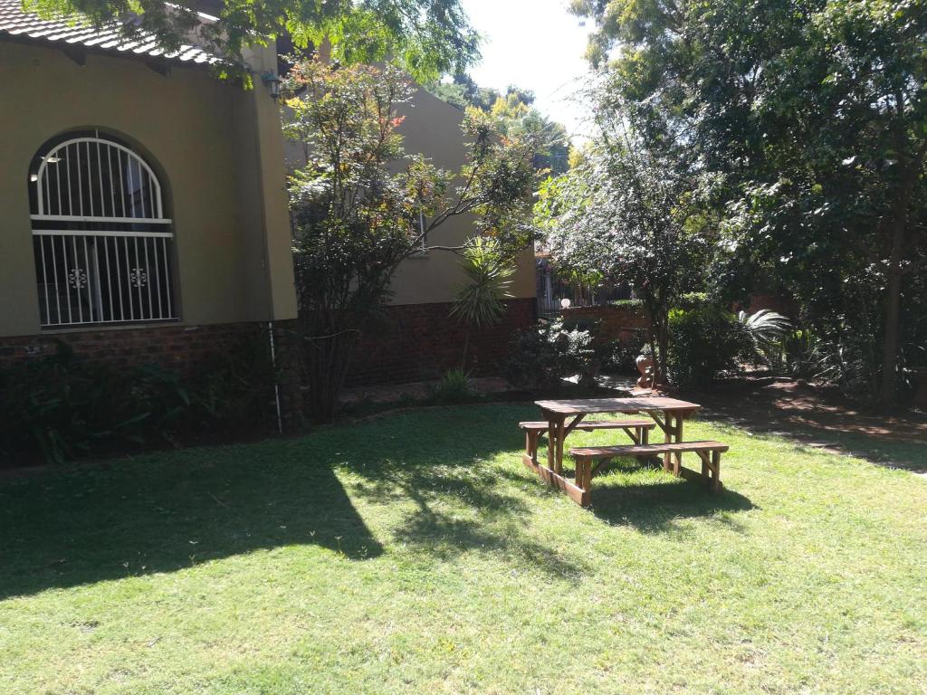 a picnic table in the grass next to a house at Harties Honeymoon suite Mountain side - Hartbeespoort dam in Hartbeespoort