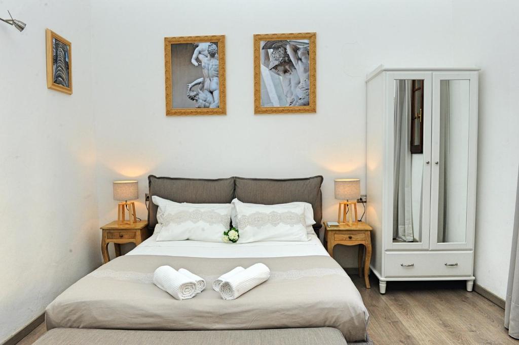 Domus Plaza في فلورنسا: غرفة نوم عليها سرير وفوط