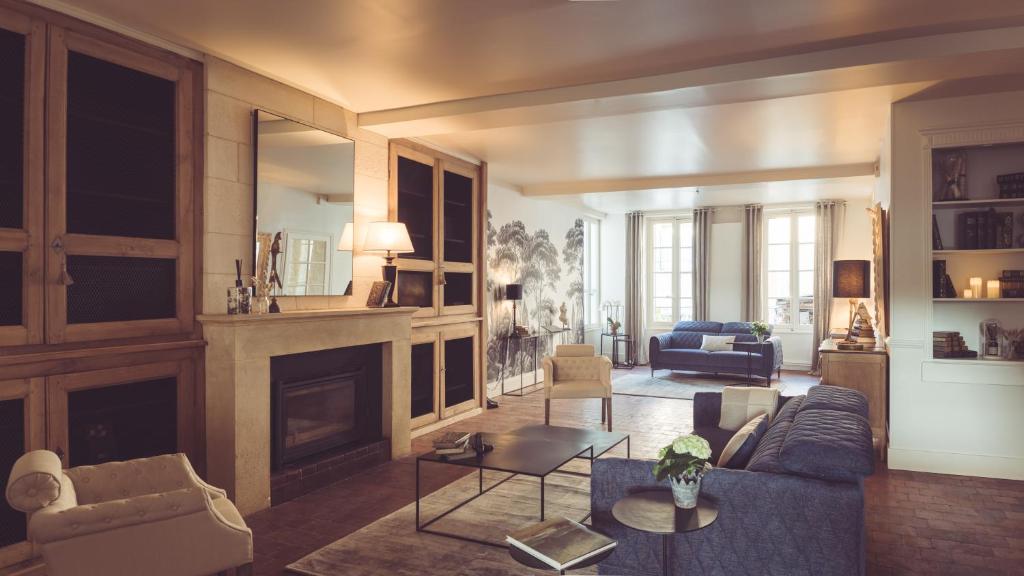 a living room with a blue couch and a fireplace at La Villa Celestine in Chablis