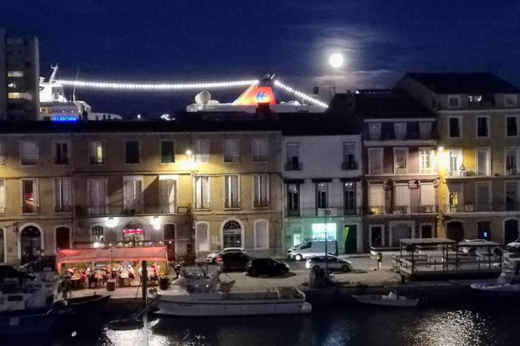 een groep gebouwen 's nachts met volle maan bij vue exceptionnelle sur les canaux in Sète