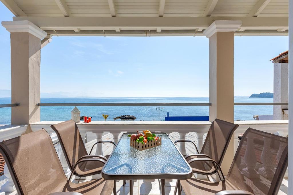 a table and chairs on a balcony with a cake on it at Albatross Apartments by Konnect, Ipsos Corfu in Ipsos