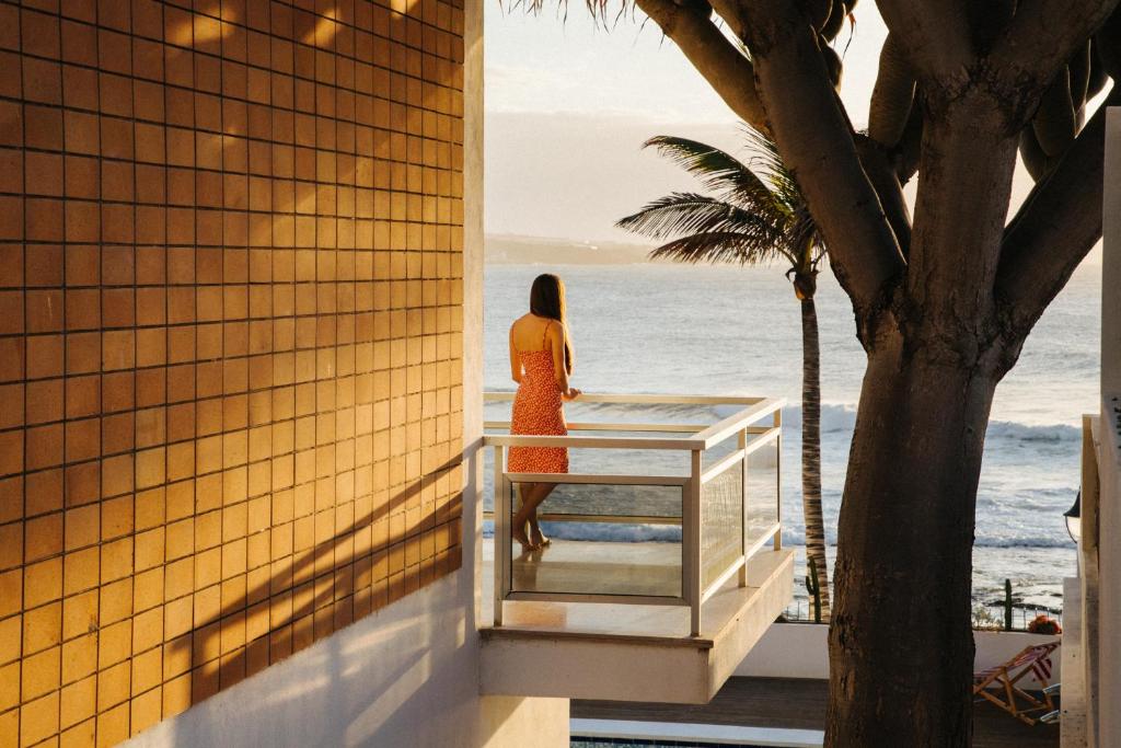 Una mujer parada en un balcón con vistas al océano en Punta Paradiso, en Punta del Hidalgo