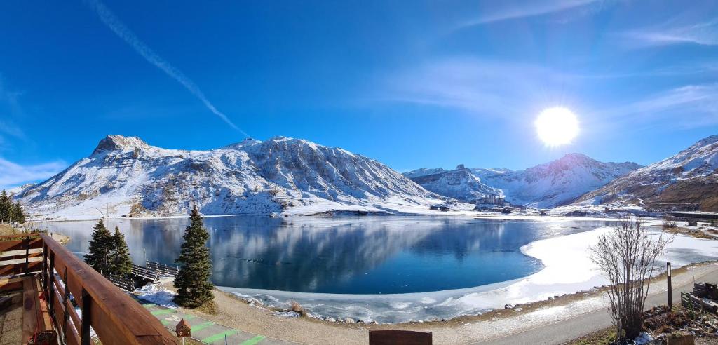 a view of a snow covered mountain range with a lake at Le Terril Blanc in Tignes