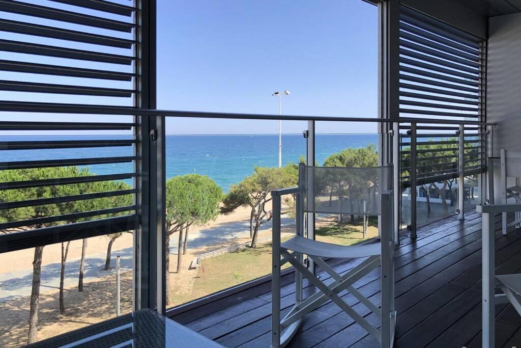a balcony with a chair looking out at the ocean at NEREIDES 31 in Platja d'Aro