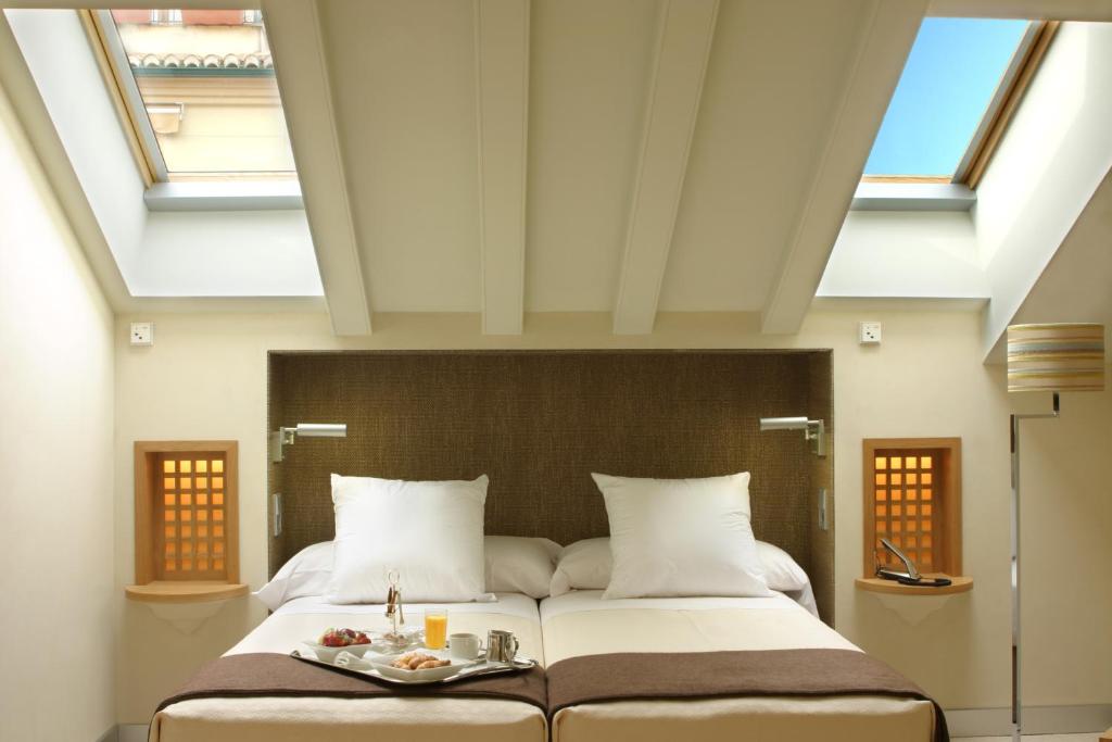 a large bed in a room with skylights at Villa Oniria in Granada