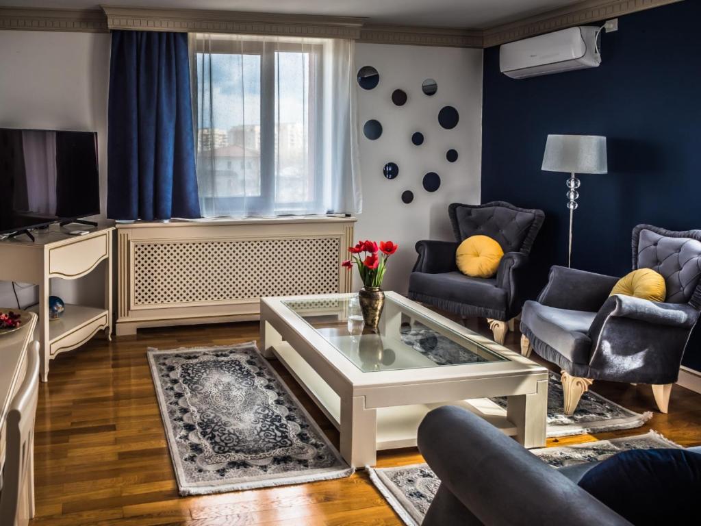 sala de estar con mesa de centro y paredes azules en Sky Park Home en Iaşi