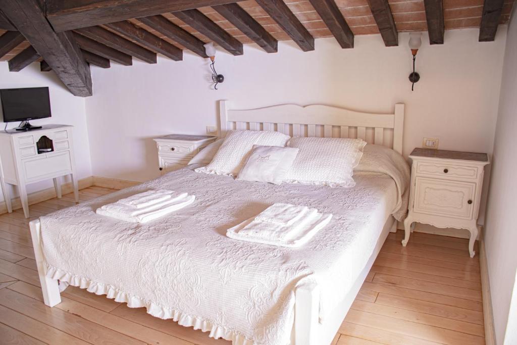 una camera da letto con un letto bianco con due asciugamani di Casa MYCONIS 68Mq a due passi dal Mare di San Vincenzo a San Vincenzo