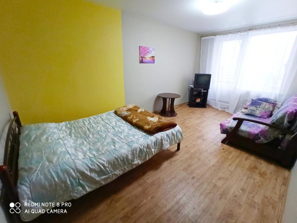 a bedroom with a bed and a chair in a room at Комфортные аппартаменты возле метро Студенческая in Kharkiv