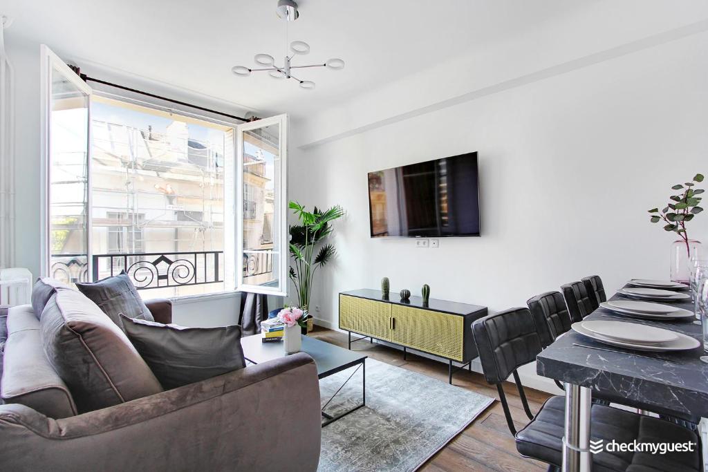 a living room with a couch and a table at CMG - Place des Vosges in Paris